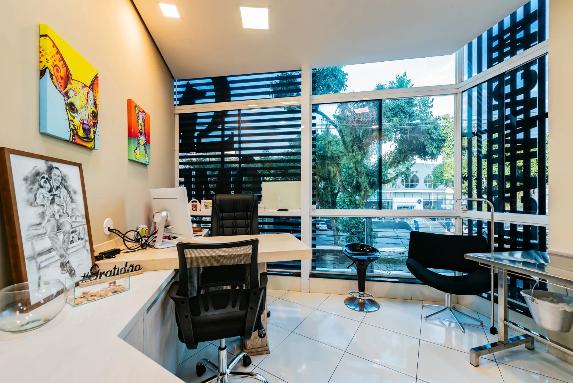 Escritório do Ômega com vista para a rua e quadros decorativos