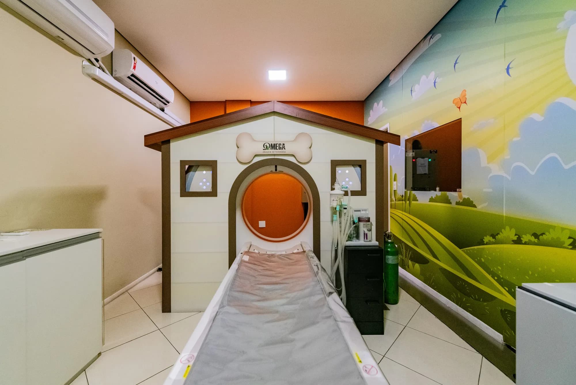 Tomógrafo do Ômega com túnel decorado e mural de paisagem